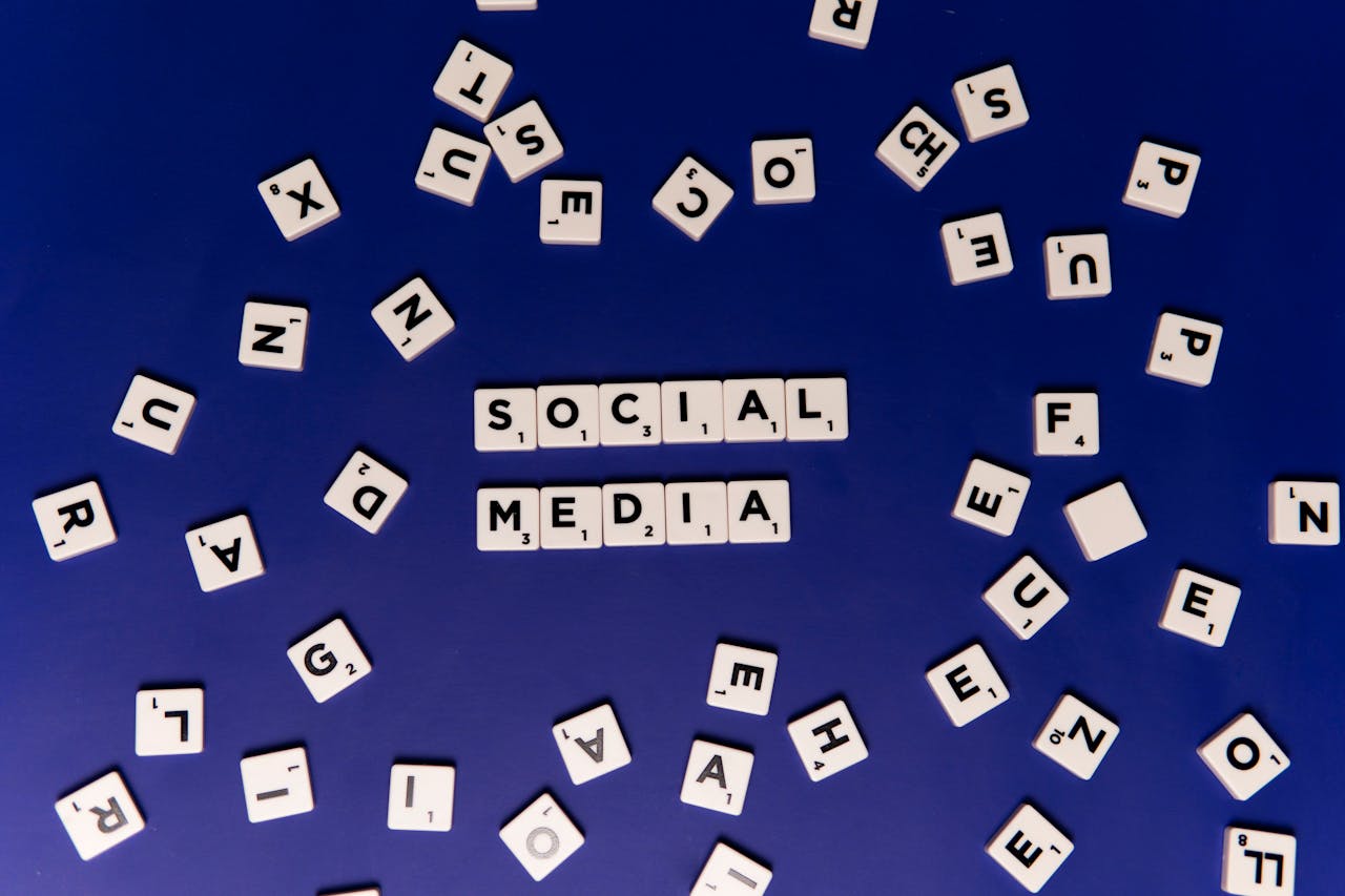 Scrabble tiles spelling Social Media on a blue background, ideal for digital marketing themes.
